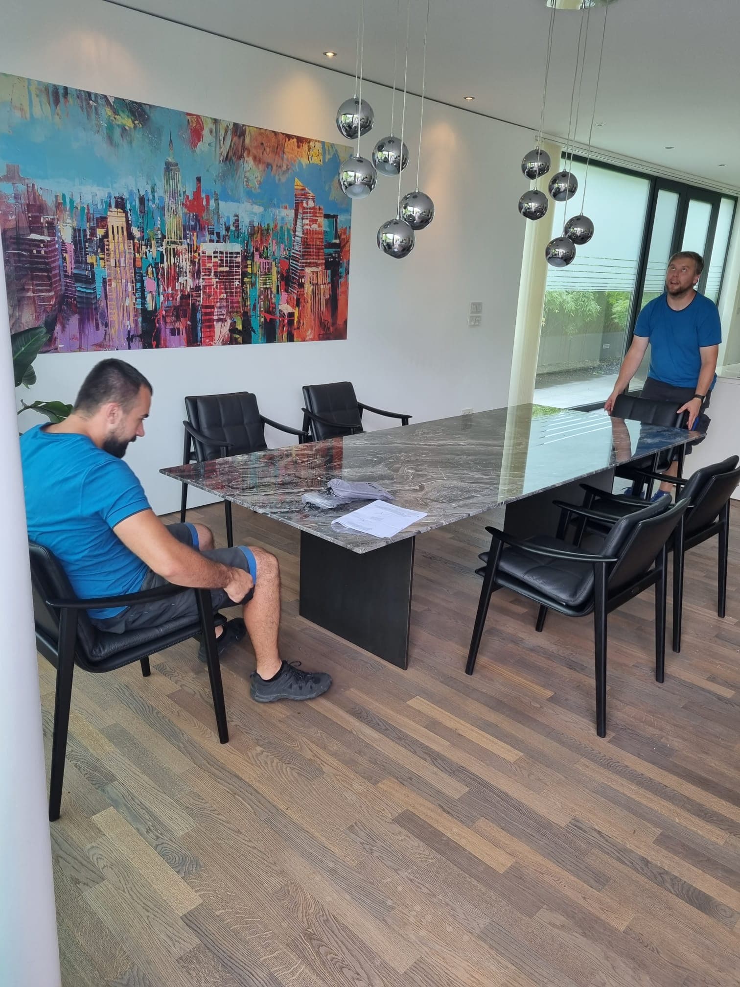 A-Team-Mitarbeiter bei der Montage eines großen Esstischs mit Designstühlen